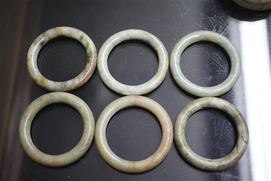 A collection of eighteen Chinese grey and green jade excavated bangles, Ming dynasty or earlier, each approx. 7.4cm diameter